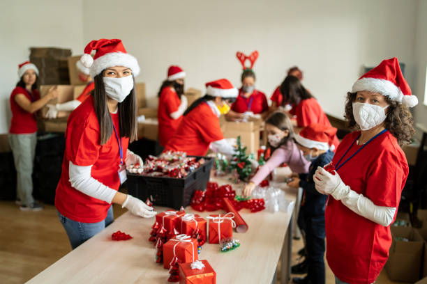 Female volunteers preparing Christmas gifts for poor people